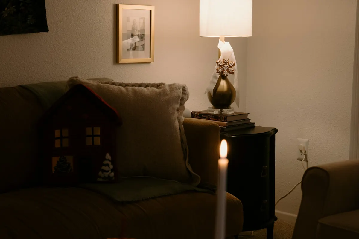 A living room at dusk with a lit lamp and a candle