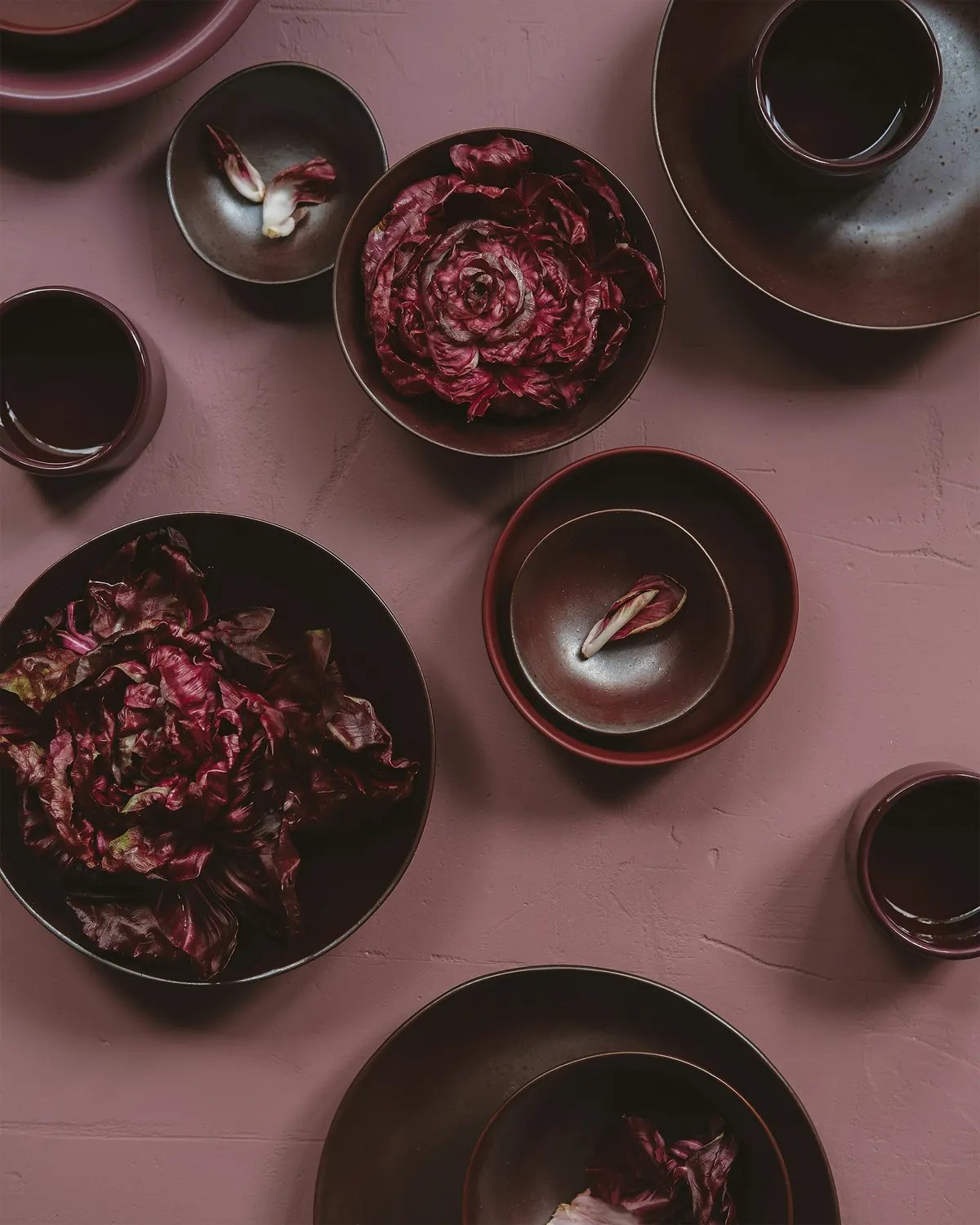 Brown and burgundy bowls on a dusty-pink surface