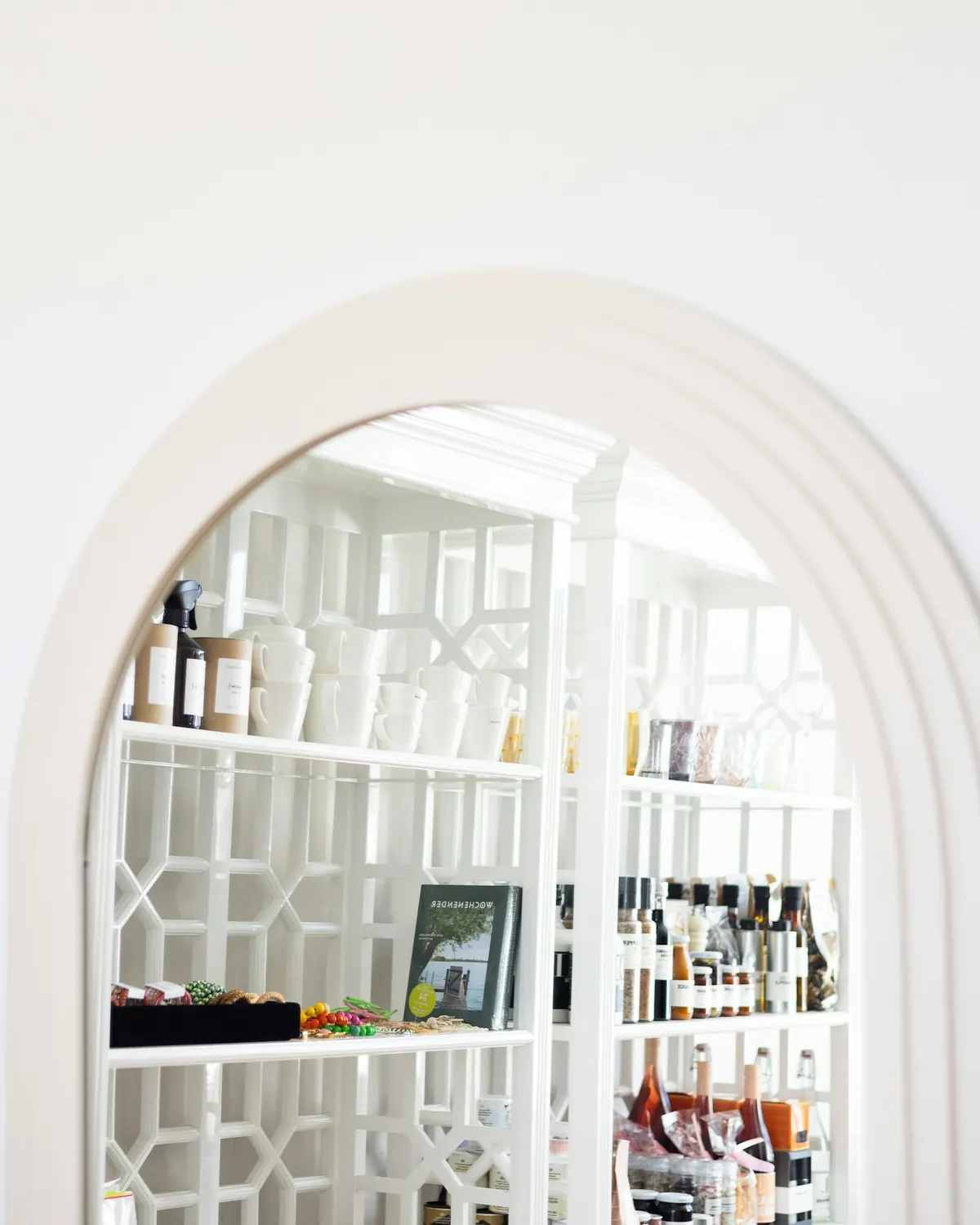A white arched opening framing patterned shelves