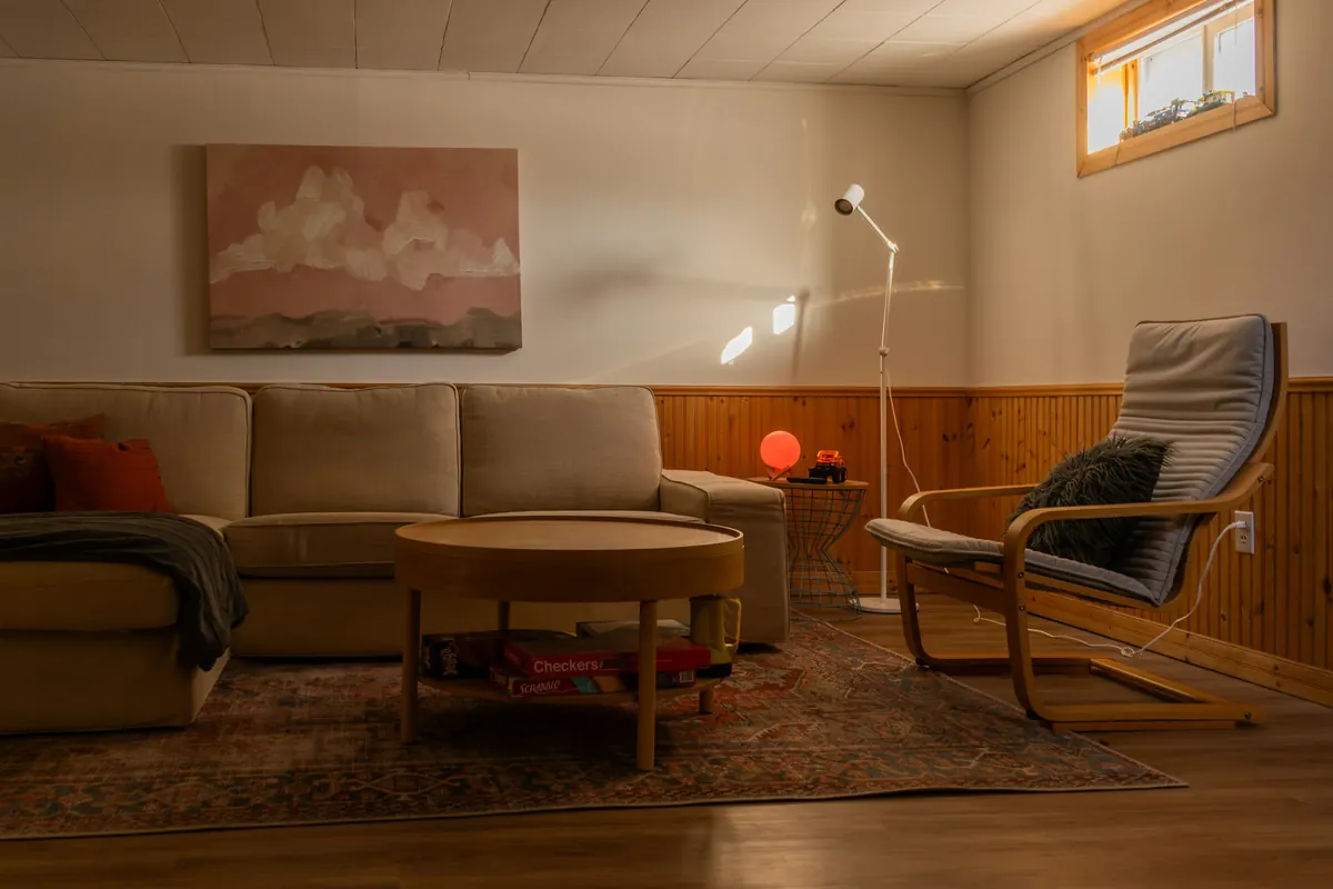 A living room lit by a floor lamp in the evening