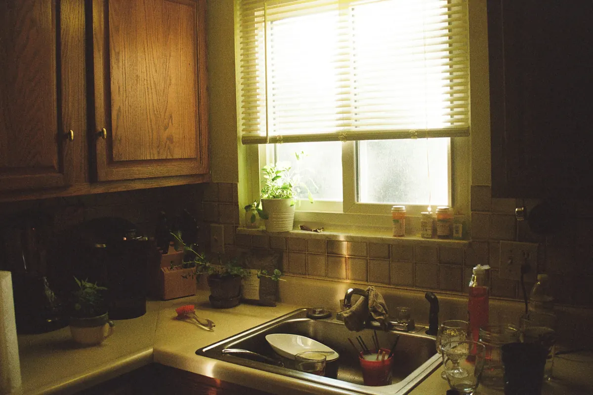 A lived-in kitchen with daylight over the sink and counter