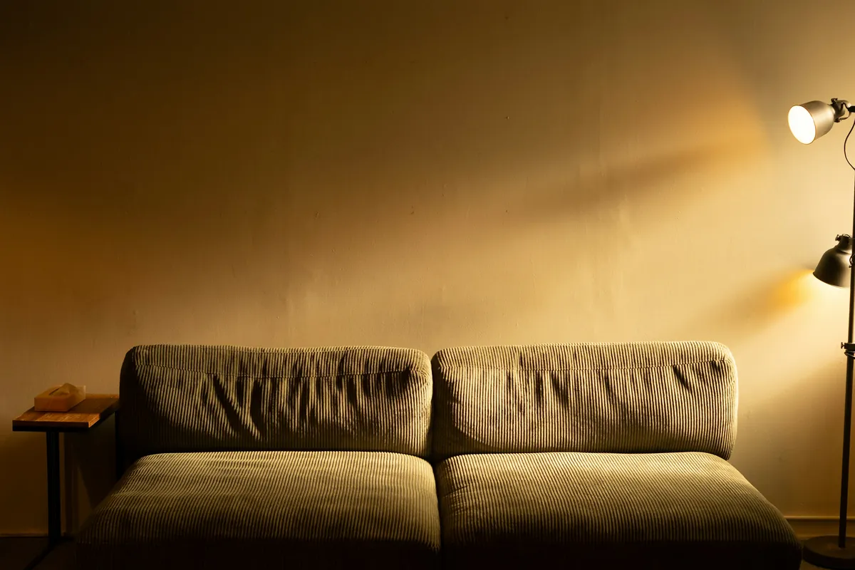 A lamp casting warm evening light over a sofa