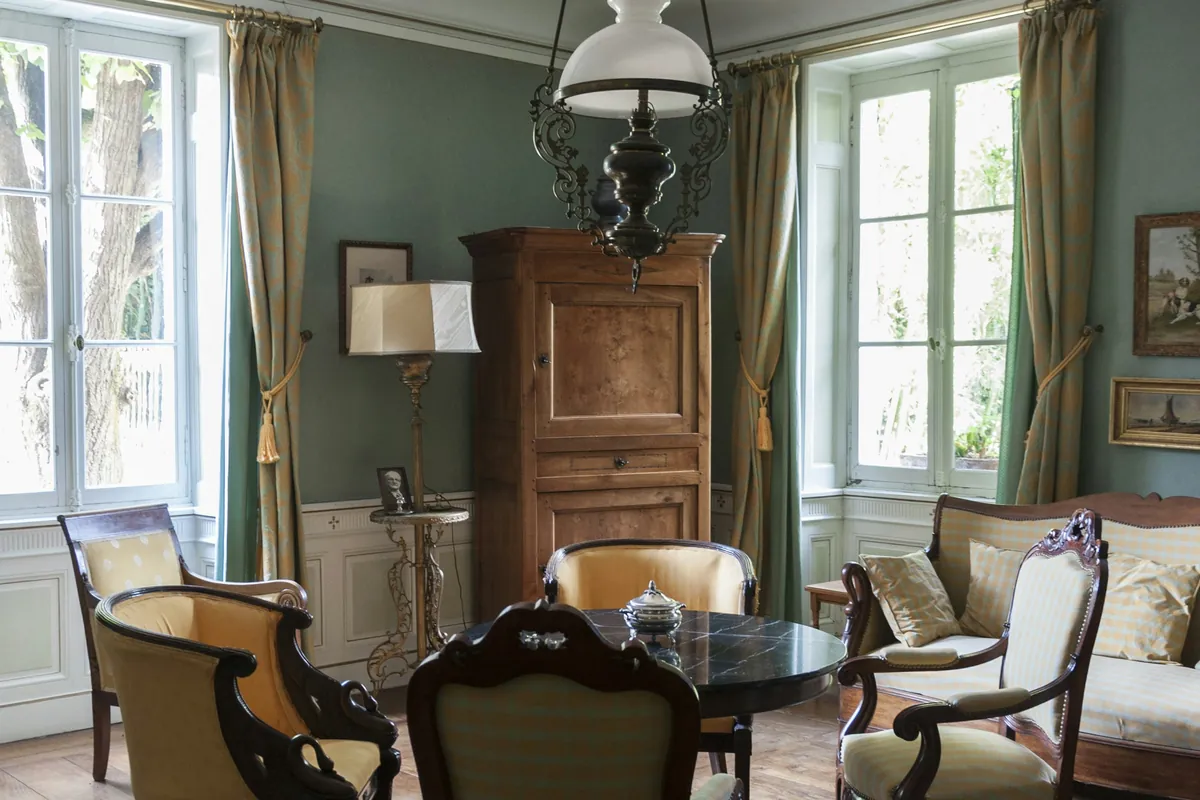 Sunlit living room with wooden floors, books and lived-in details