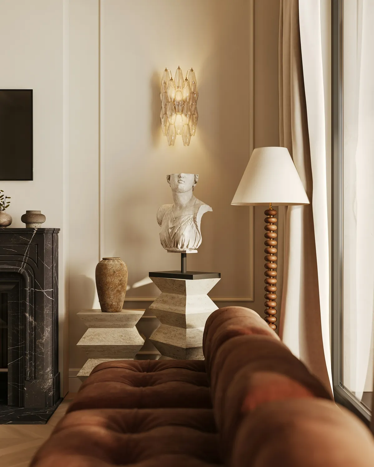 Classical bust and marble fireplace beside a contemporary lamp and a velvet sofa