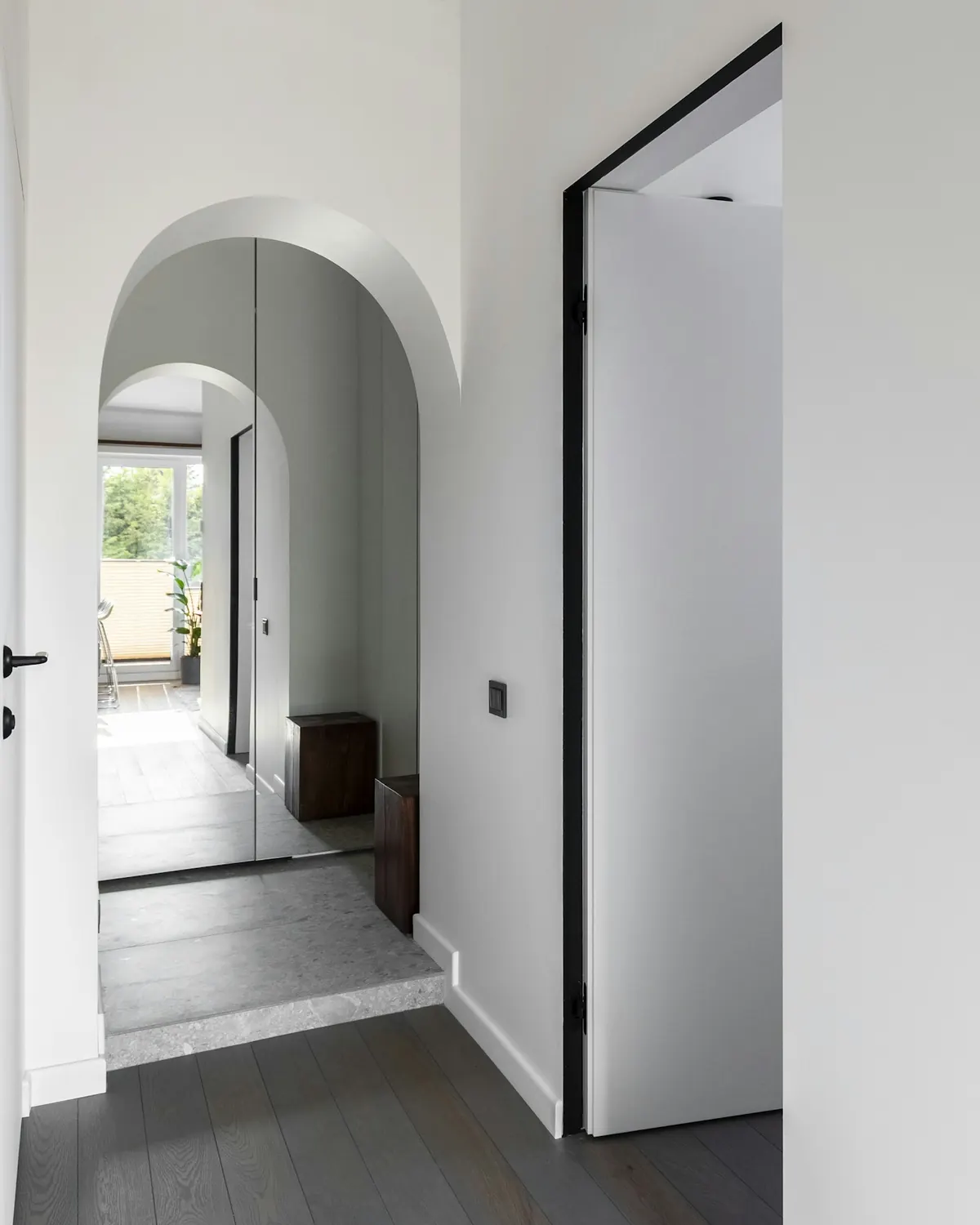 A narrow white entry with an arched doorway