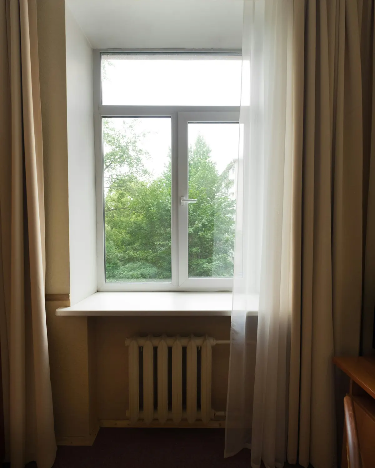 A window framed by long curtains letting in soft daylight