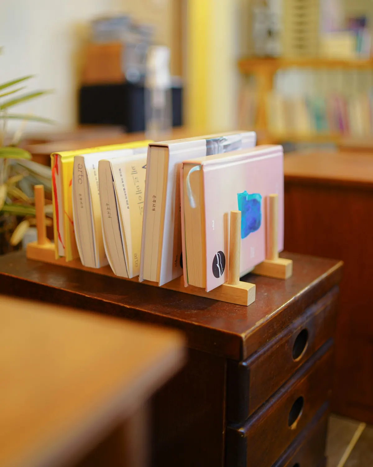 A wooden letter holder with notebooks on an old desk