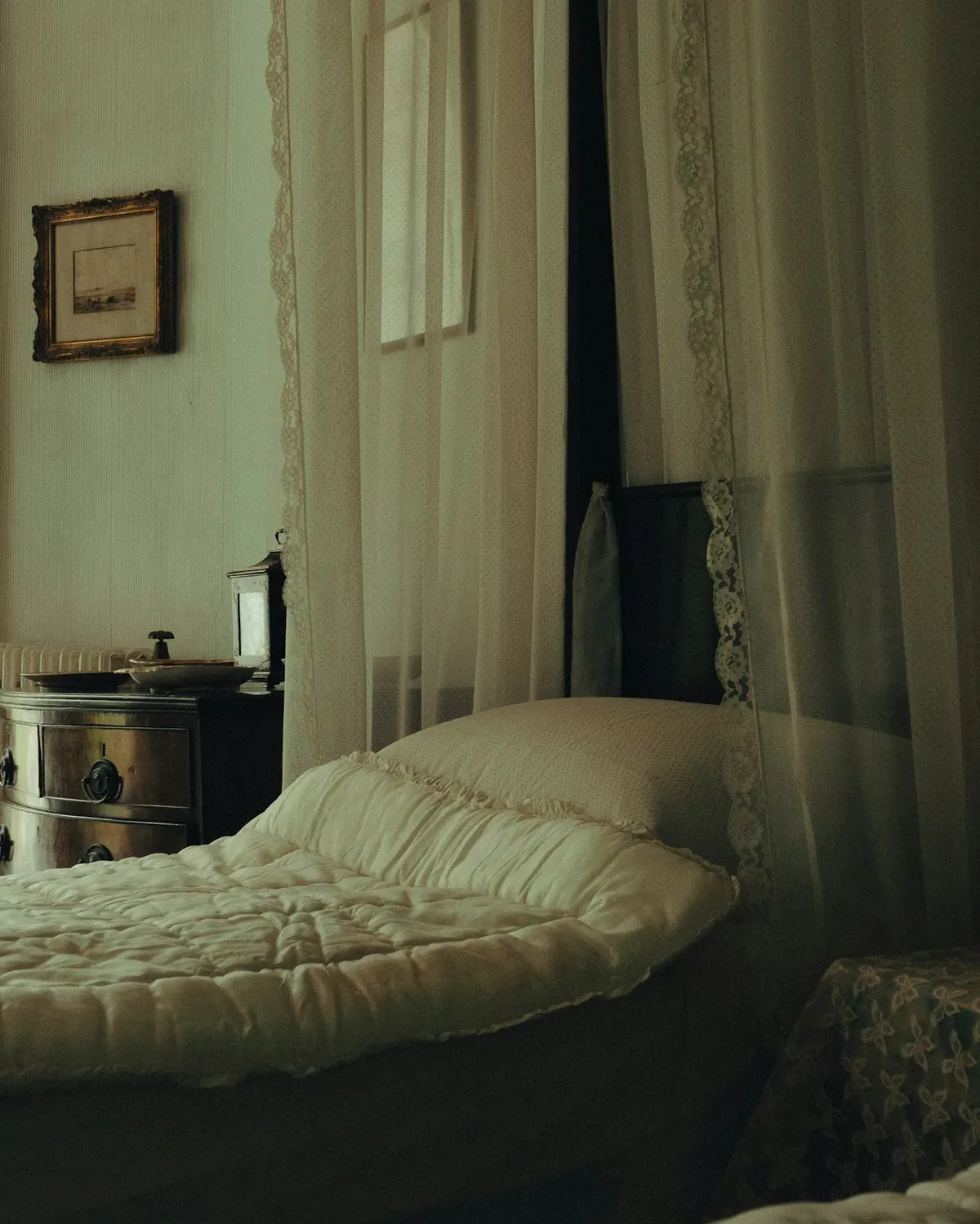 An old quilted bedspread in a softly lit bedroom
