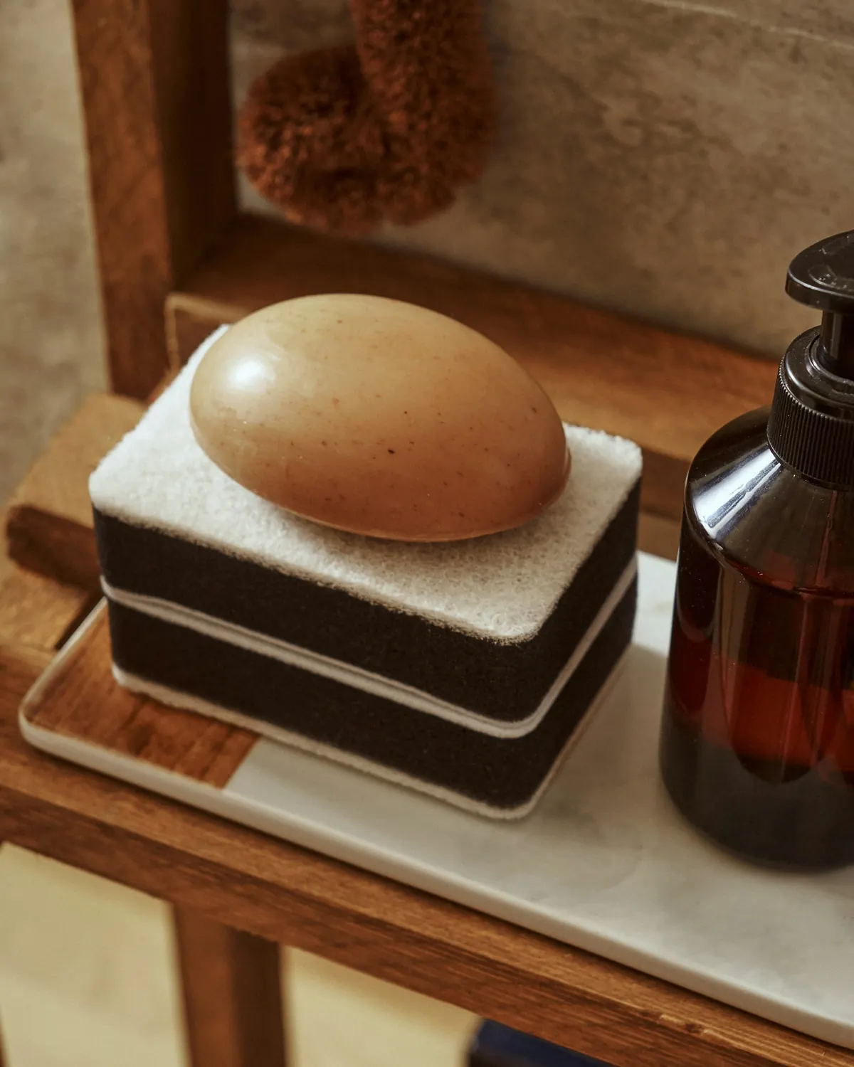 A soap and a dish on a small tray on a wooden shelf