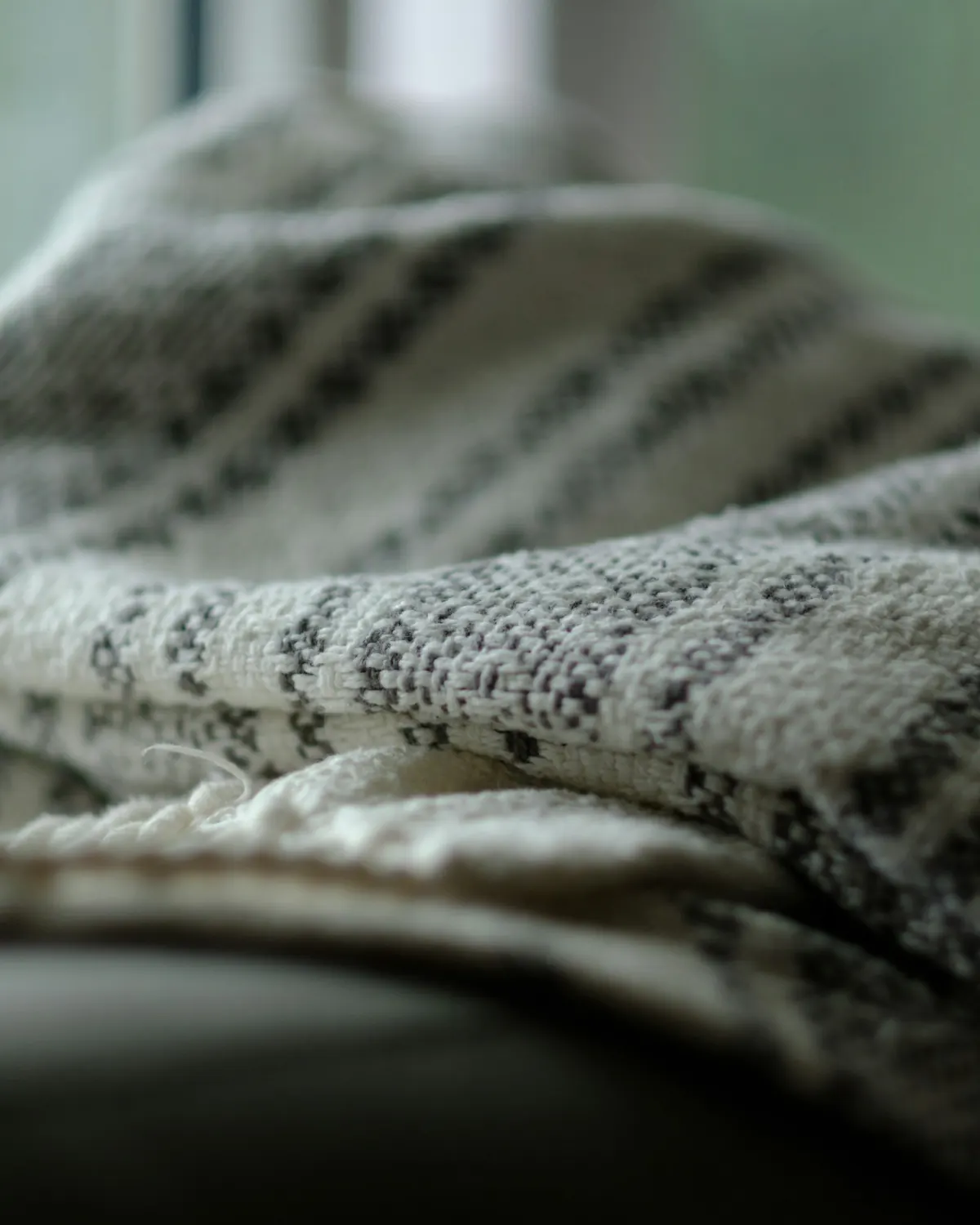 A patterned wool throw draped over a sofa