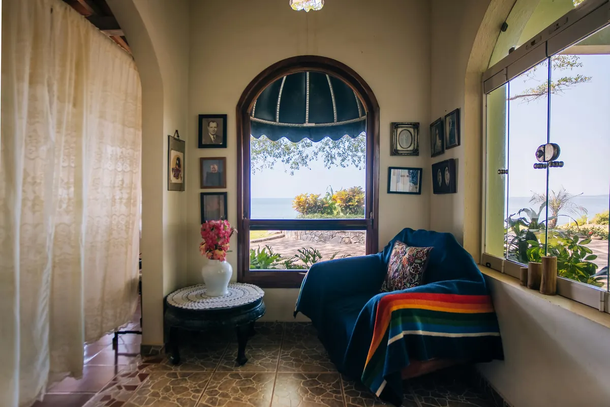 A reading nook with a striped blanket beneath an arched window