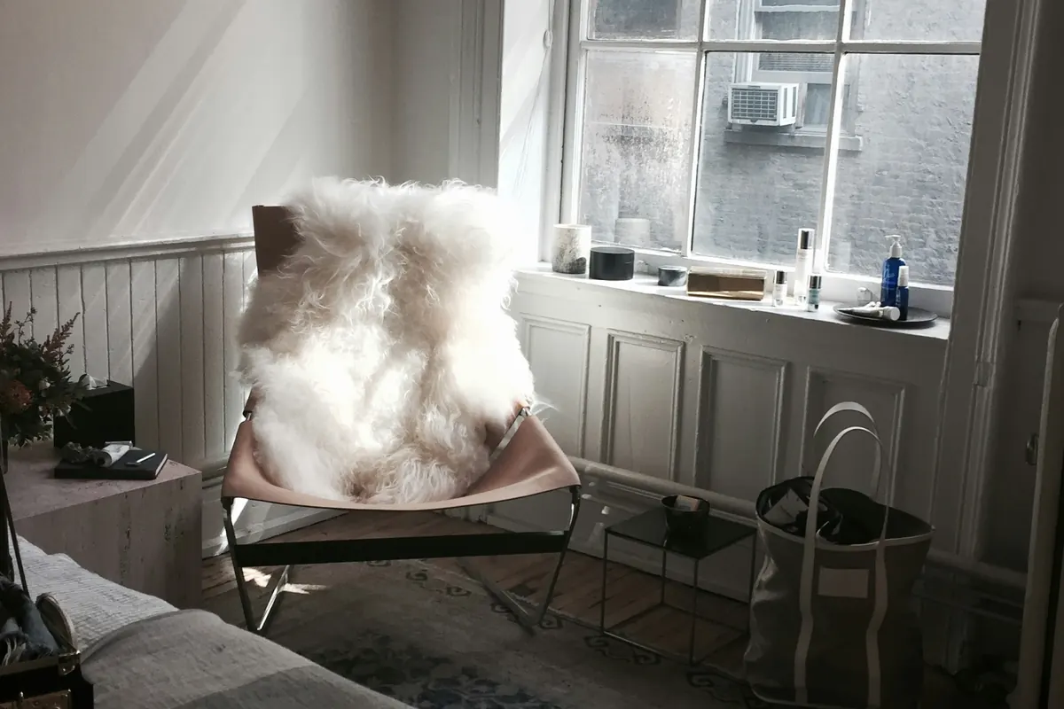 Soft winter daylight entering a quiet room with a sheepskin chair