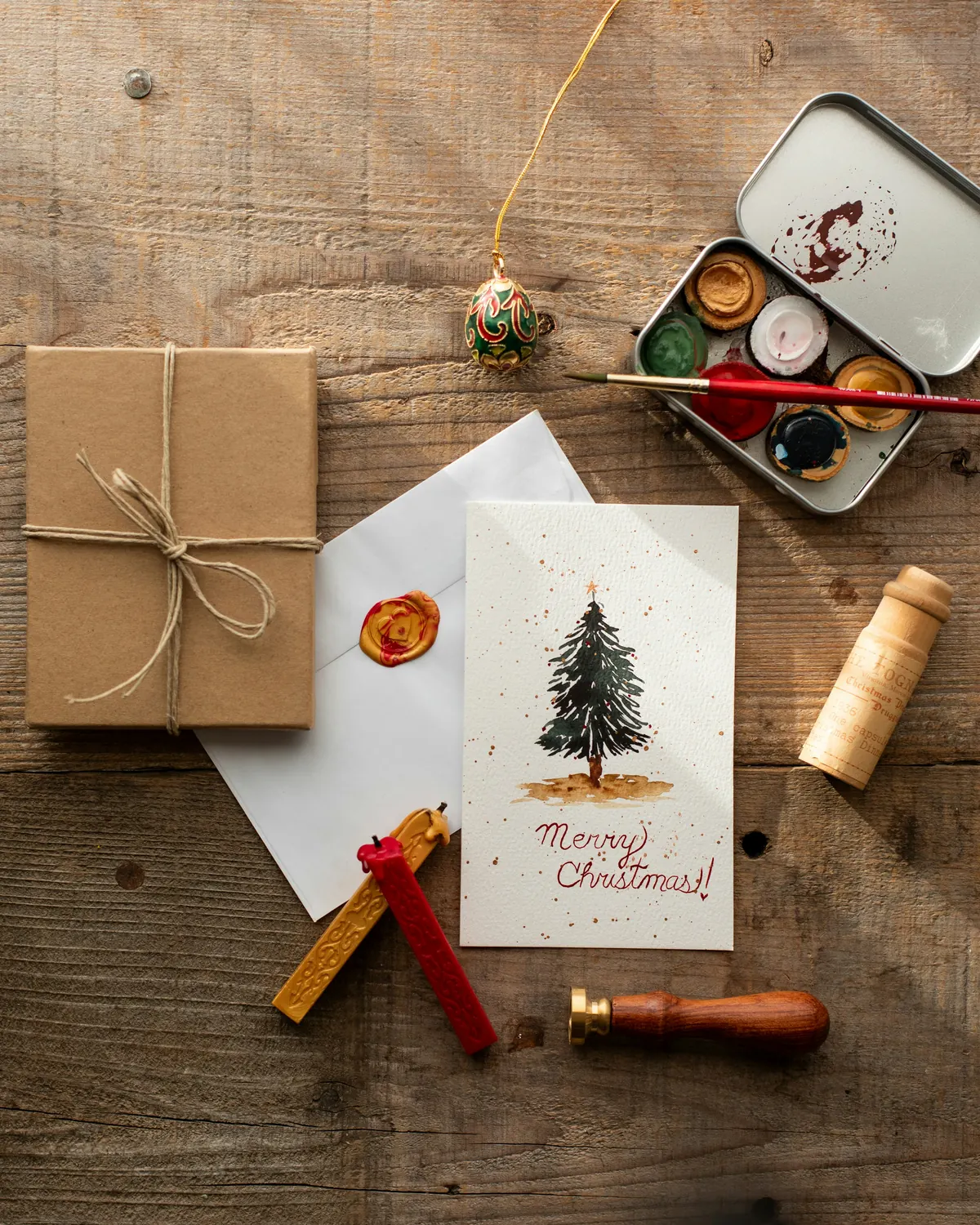 A hand-painted holiday card with kraft paper and string